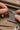 Person working with gold chain and jewelry tools on a wooden surface