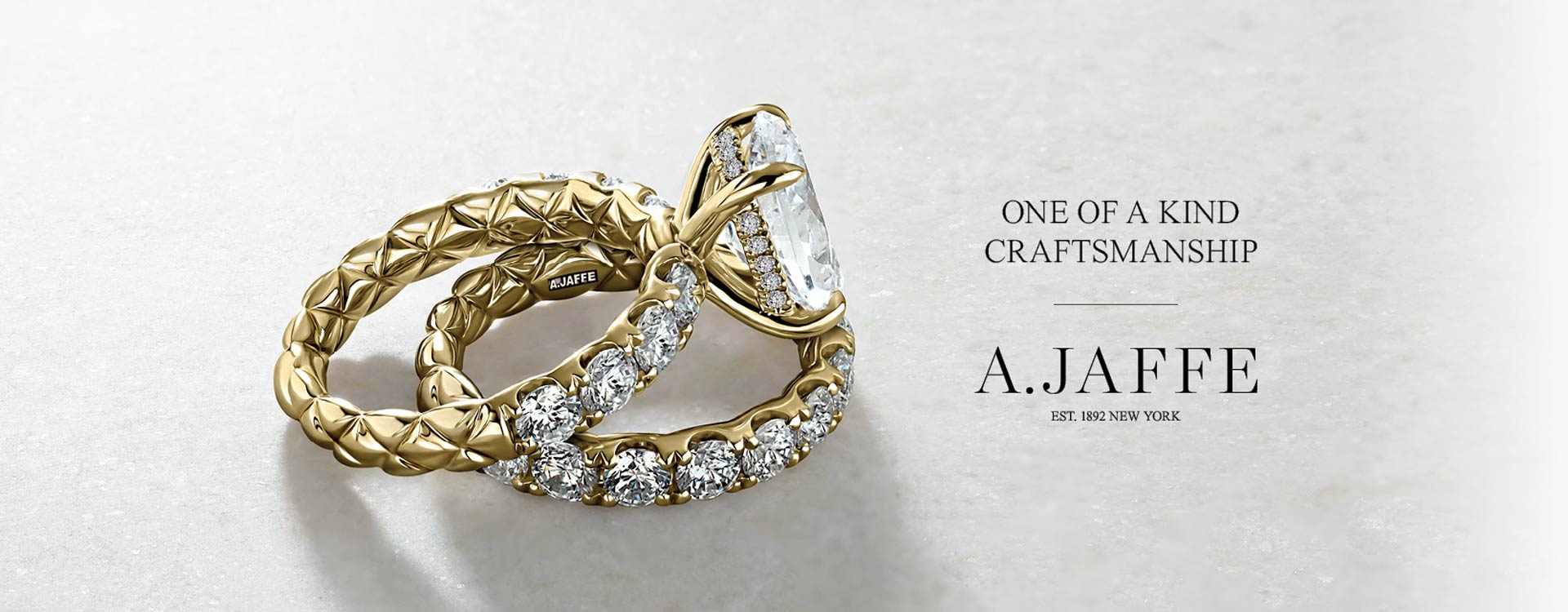Gold ring with diamonds on a light gray background, featuring A.Jaffe branding.