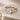 Gold ring with a diamond on a beige stone surface
